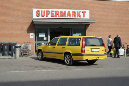 Gelber Volvo 850 hochgelegt vor Supermarkt